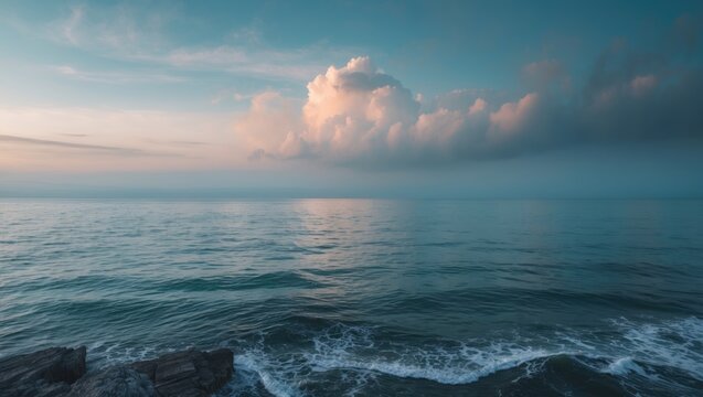 Calm sea view from the shore with clouds in the sky. Tranquil ocean scene. Nature and water landscape. The scene of peacefulness and serenity at sea