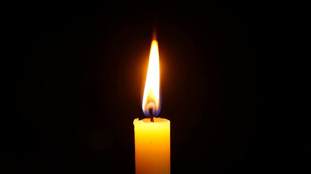Warm glow of a lit candle flickering gently in a dark space, creating a peaceful and calming mood.