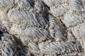 Close up of thick white braided rope showing frayed fibers
