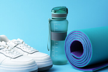 Fitness gear including a sports water bottle, running sneakers, and an exercise mat