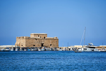 ruins of a medieval stone castle and motor boats in the port of Paphos