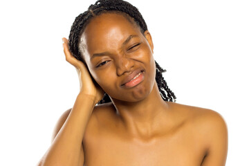 Black woman showing discomfort and holding her ear, expressing pain or irritation, studio shot on...