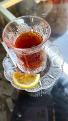 Baku, Azerbaijan - July 3, 2023: Traditional Azerbaijani tea in a crystal glass with a slice of lemon