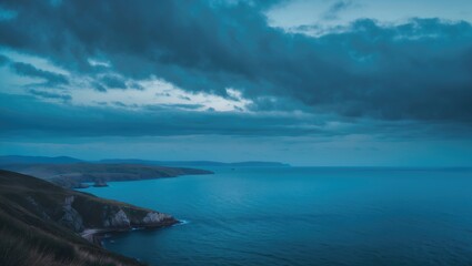 Obraz premium Coastal landscape under dark clouds with ocean view and distant landforms. Nature scenery and seascape. Atmospheric weather and horizon.
