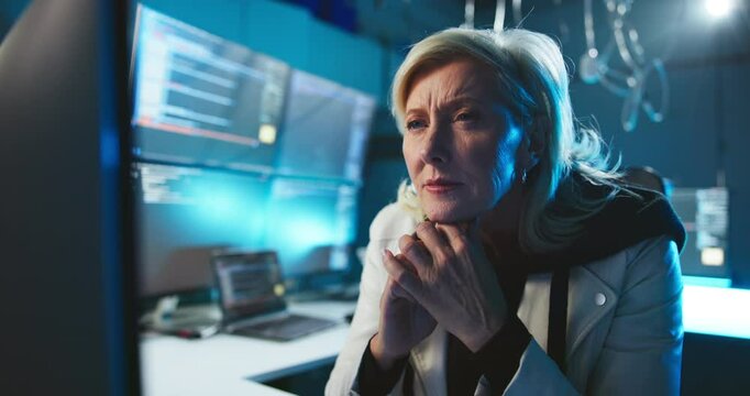 Thinking, reading and woman in cybersecurity with computer for network traffic, system update and overtime. CISO, night and mature person in office for software installation and data breach solution