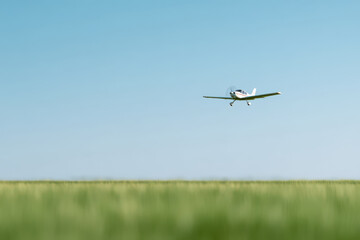 serene scene of light airplane soaring gracefully over vast green field soft bokeh effect creating dreamy