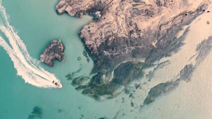 Enjoying a thrilling ride on a speedboat near a beautiful beach