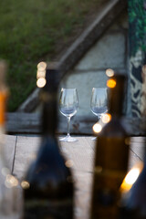 empty wine glass seen through bottles
