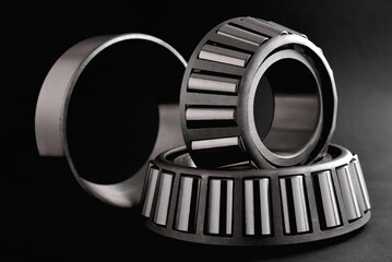 roller bearings on a black background, blank for creativity. Parts for machines and mechanisms in...