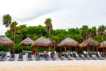 Fototapeta premium Palapa thatched roofs palms parasols sun loungers beach resort Mexico.