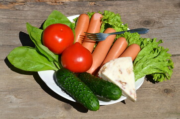 A plate of sausages and suluguni cheese with added vegetables and spices.