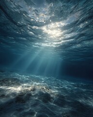 A tranquil underwater scene in soft blue hues with sunbeams filtering down from the surface