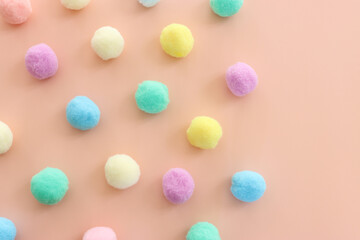 Colorful pastel cotton balls on pink background