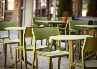 Empty plastic chairs and tables in a street cafe early morning, table for two.