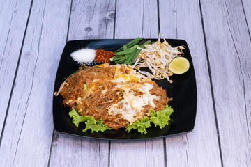 a Thai dish that consists of rice noodles fried with egg, vegetables, and spices, sometimes with pieces of meat or seafood added