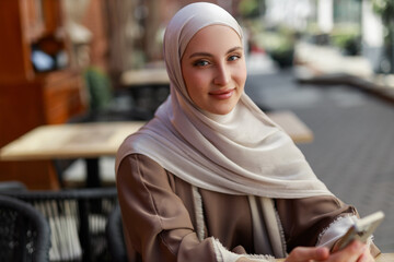 Portrait of an Arab woman in a headscarf with a mobile phone	

