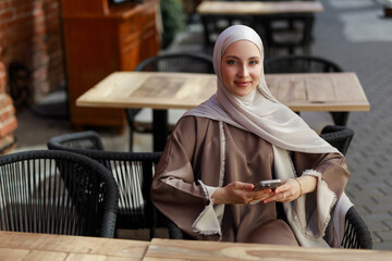 Portrait of an Arab woman in a headscarf with a mobile phone	
