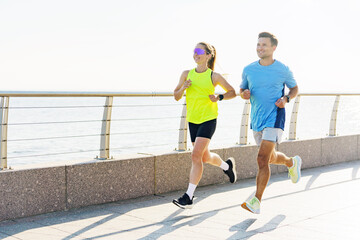 Bright morning joggers enjoying a vibrant run along a scenic waterfront promenade