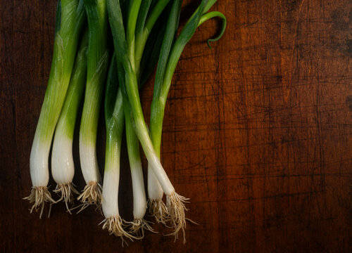 Bunch of scallions against rough cutting board