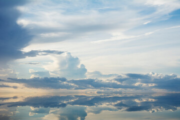 Sunset clouds reflected in calm water surface