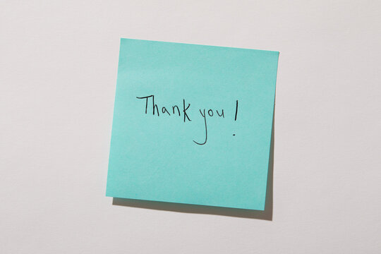 Thank you written on turquoise post it note on wall