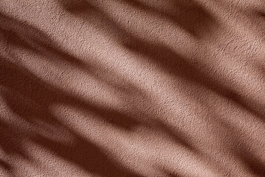 Sunlight and shadows on brown wall