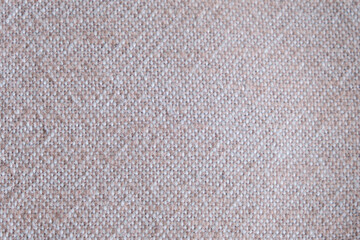 Fototapeta premium Close-up of beige woven textile texture. Macro shot of coarse fabric pattern with visible interlaced threads. Interior design and textile industry concept. 