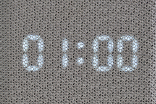 Digital timer showing 01:00 minutes displayed through mesh textile surface. Macro shot of illuminated electronic countdown digits. Technology and timekeeping concept for design and print - Powered by Adobe