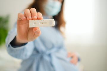 Expecting mother analyzing molecular diagnostic test outcome. Important infection control measure in prenatal care routine.