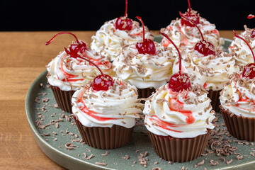 Chocolate Cupcakes with Cream Frosting Cherries and Chocolate Shavings