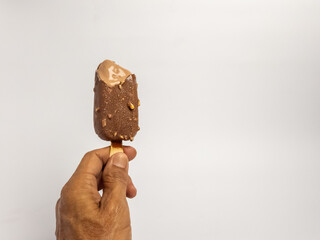 Hand holding a delicious chocolate-covered ice cream bar on white background