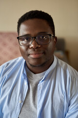 Confident young African man sitting in his living room at home