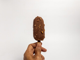 Hand Holding Delicious Chocolate Covered Ice Cream Bar with Nuts