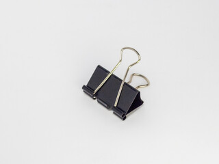 Close-up of a black binder clip isolated on a clean white background