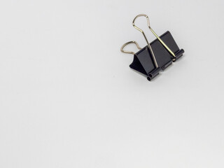 A Close Up Shot of a Black Binder Clip on a White Background