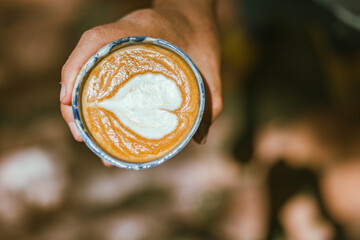  a cup of hot latte art coffee on blur background..