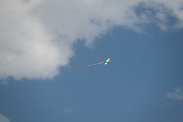 A kite flying in a cloudy blue sky.