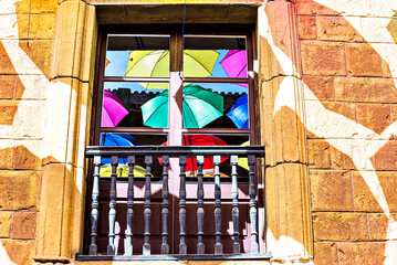 Set of colorful umbrellas, reflected in the window panes of a building