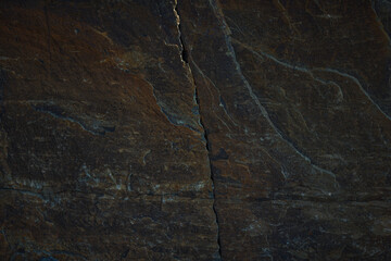 A textured stone background featuring a brutal, monolithic rock formation with cracks and fragments. Perfect for design templates, banners, or natural-themed projects, showcasing raw power and natural