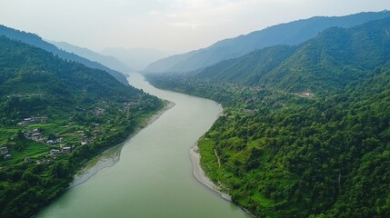 Green river flows between mountain sides covered with forest. Use this image to create a design for travel or outdoor ads.