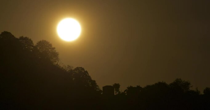 Time-lapse footage of the sunset from a mountaintop, through the forest.