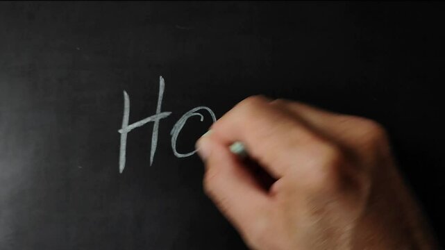 hand writing Word "hope" on a blackboard