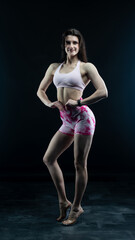 Obraz premium Confident fitness model posing on black background showing muscles 