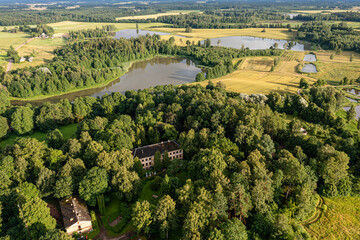 Historic estate surrounded by greenery and tranquil water bodies in rural landscape