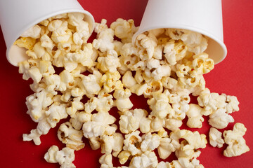 Delicious popcorn in a bucket on a red background. Tasty snack