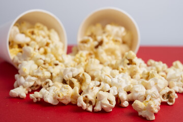 Delicious popcorn in a bucket on a red background. Tasty snack