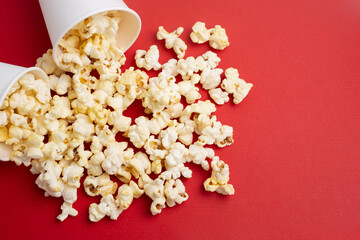 Delicious popcorn in a bucket on a red background. Tasty snack