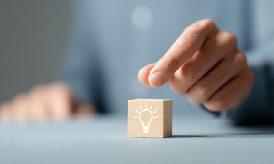 Creative design using wooden blocks with the bulb symbol represents the generation of unique ideas, strategies and thinking in business and marketing