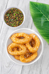 Crispy battered calamari rings with sesame seeds and spicy Asian dipping sauce