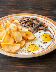 Golden potato dippers, fried eggs, and mushrooms on rustic textured table setting